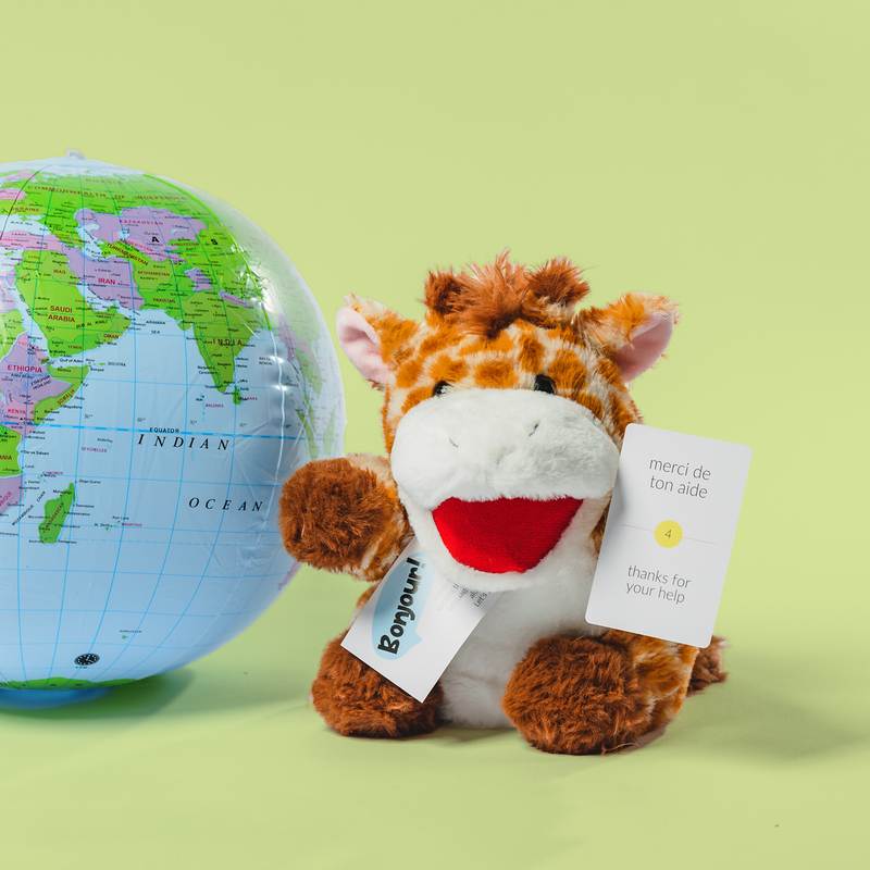 Plush giraffe toy with a globe on a green background