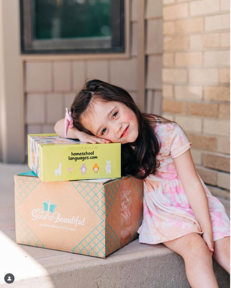 Smiling girl resting on a Homeschool Languages curriculum box